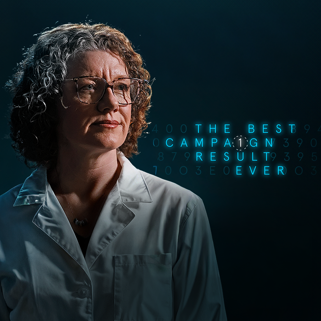 Portrait of a woman in a lab coat with the text "The Best Campaign Result Ever" in a digital-style font in the background.
